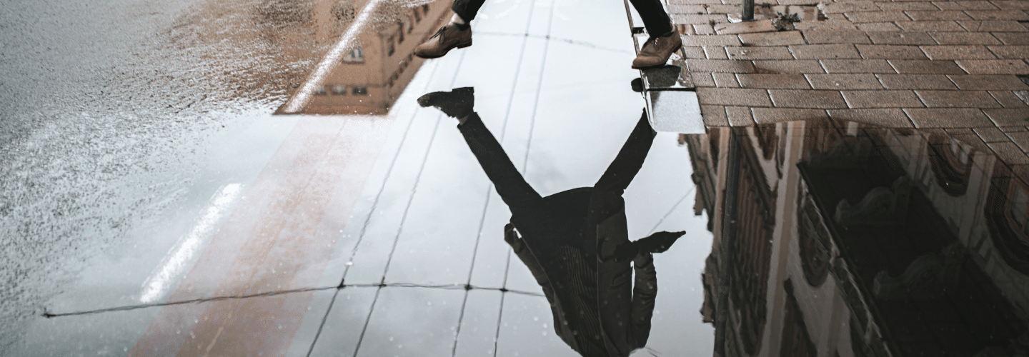 Man stepping over puddle